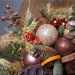 Новогодний букет Лулео с еловыми ветками, шишками, цветком лотоса, новогодними игрушками и сушеными апельсинами в Санкт-Петербурге - Фотография 3