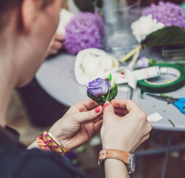 Флорист за работой над оформлением свадьбы в фиолетовых тонах